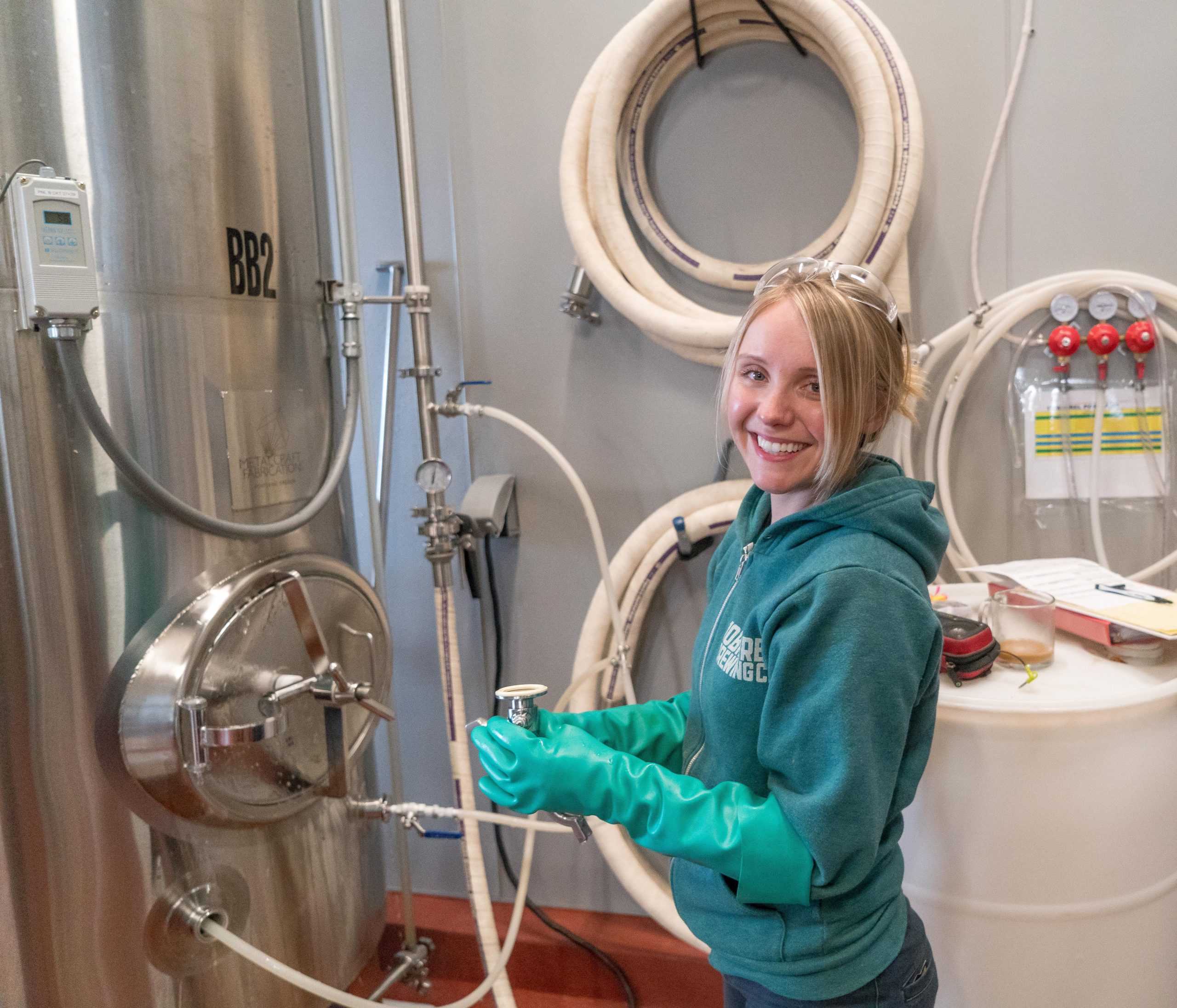 Foto de uma cervejeira analisando a produção de cerveja em fábrica