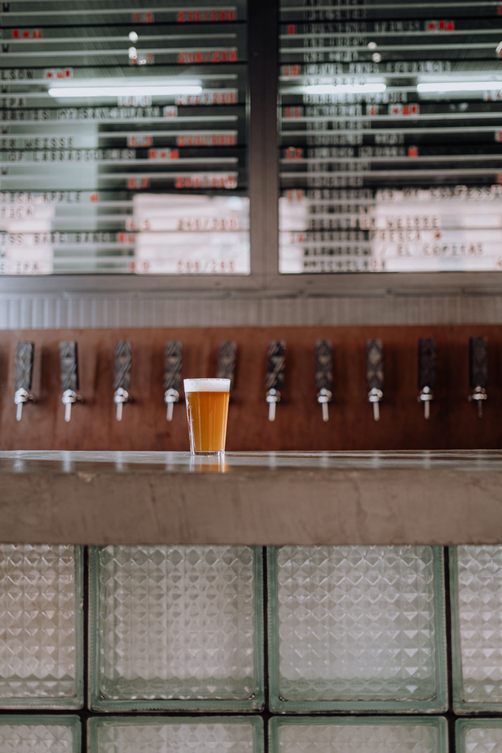 Imagem de um balcão, com vários torneiras de chope e um pint servido
