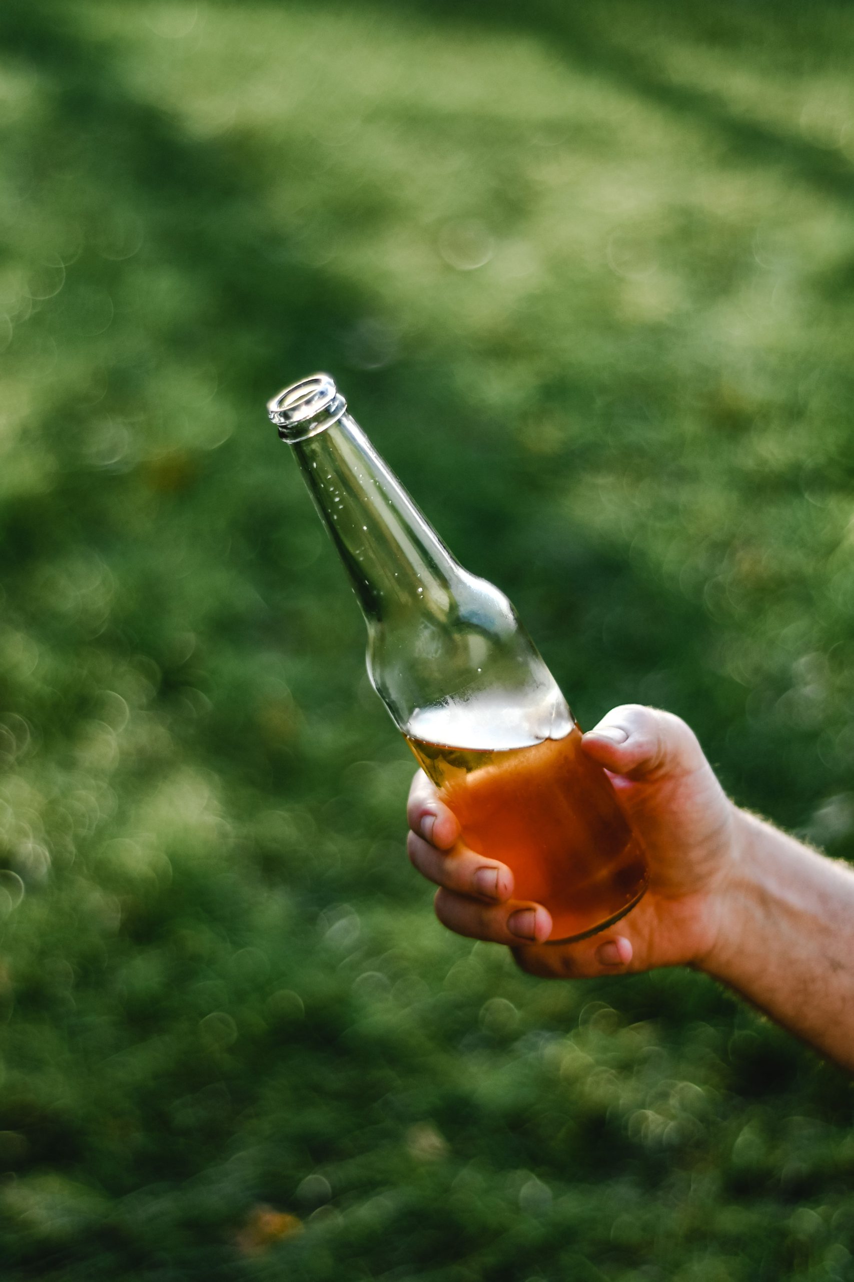 Mão segurando garrafa de cerveja