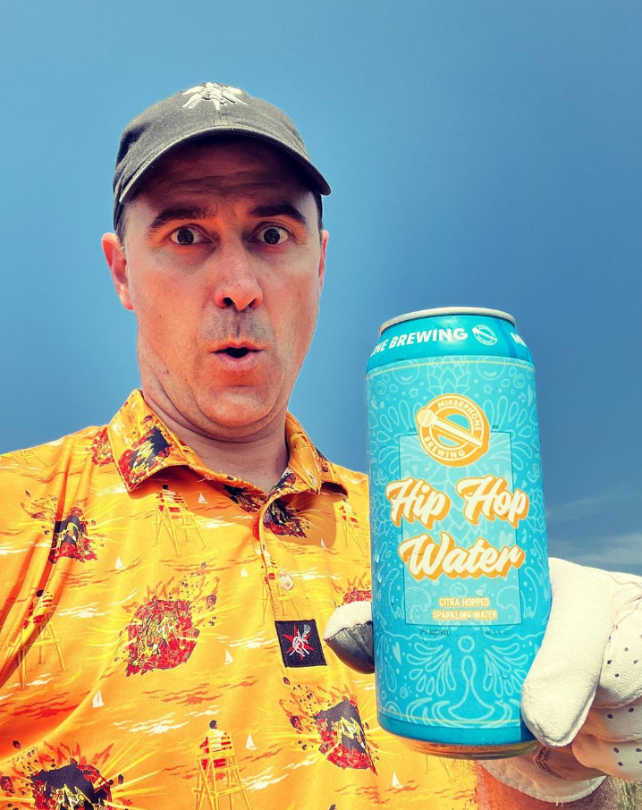 Doug Veliky segurando uma cerveja e céu azul ao fundo