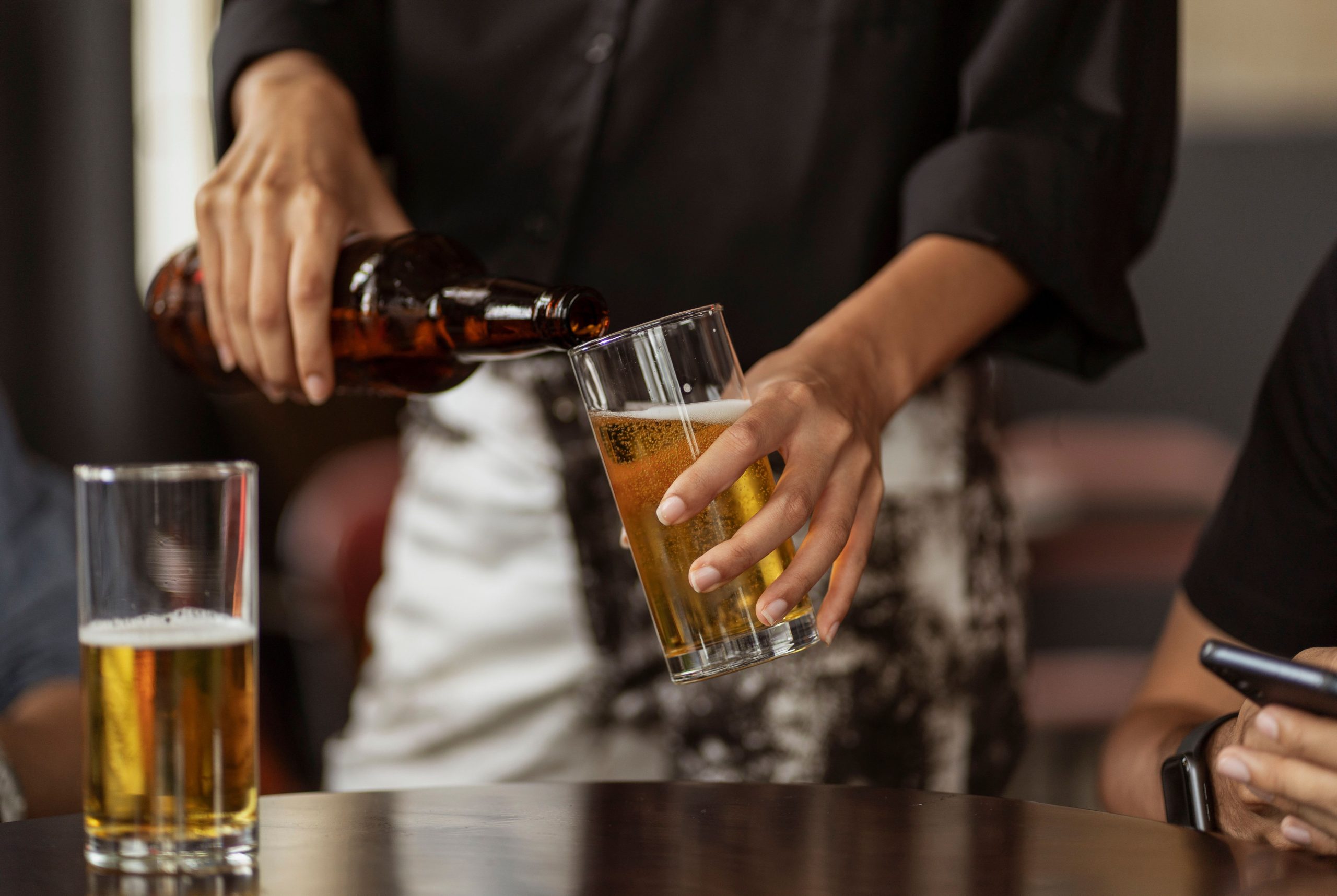 Garçom servindo chope na mesa de clientes