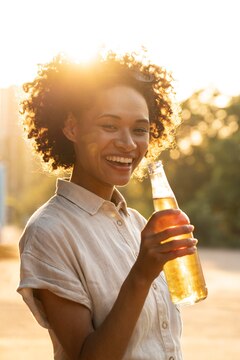 Mulher negra de cabelos cacheados bebe uma IPA