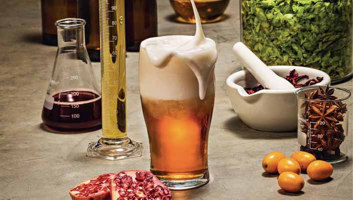 Imagem de cerveja ao lado de itens utilizados para sua produção