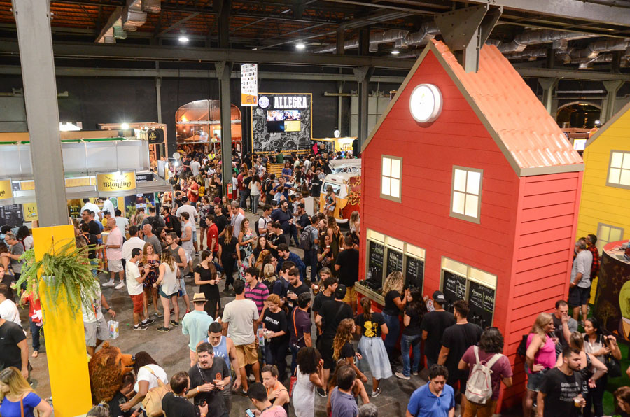 Foto do evento com diversos estantes e pessoas andando