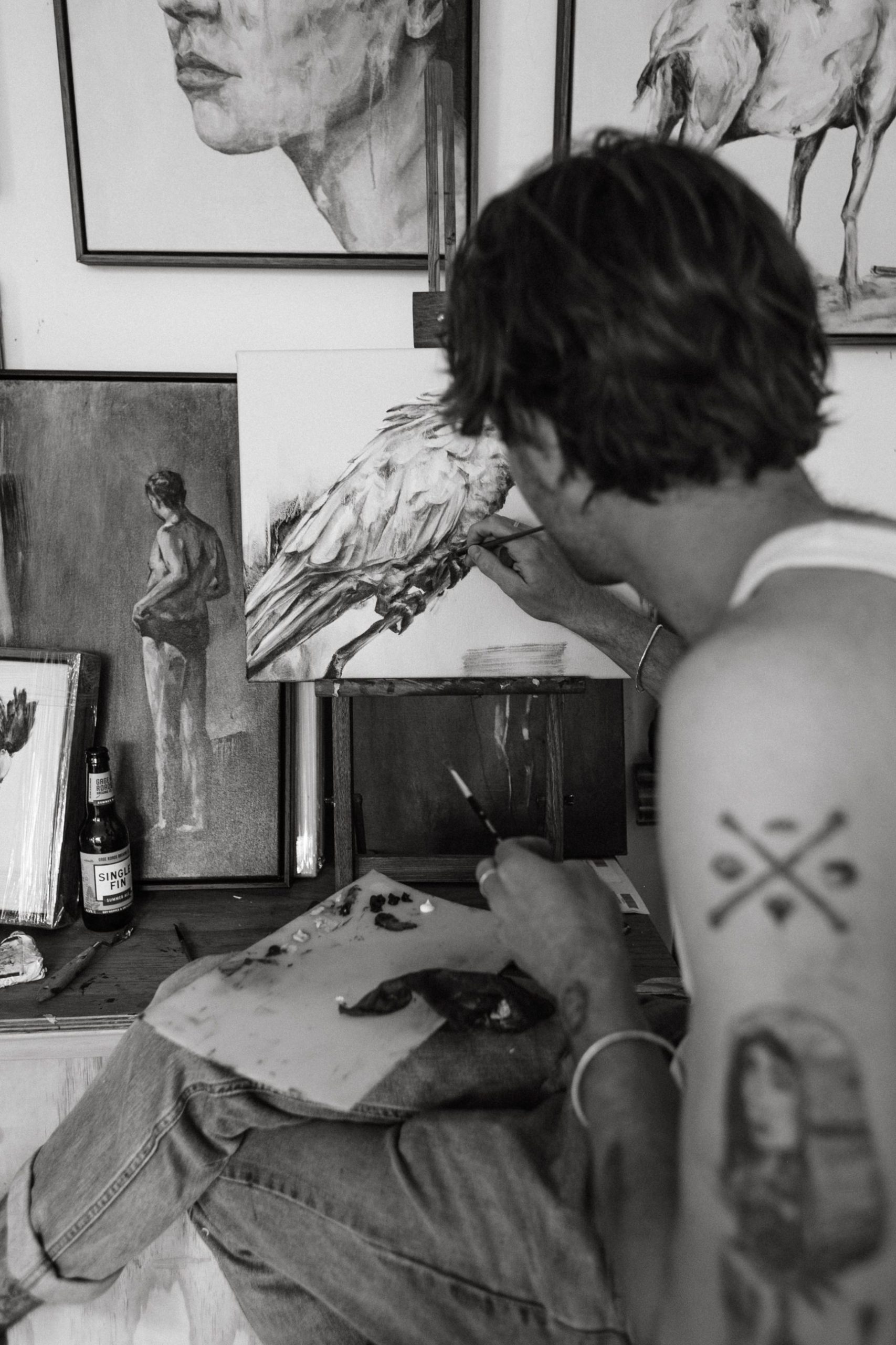 Foto em preto e branco de jovem fazendo uma pintura.