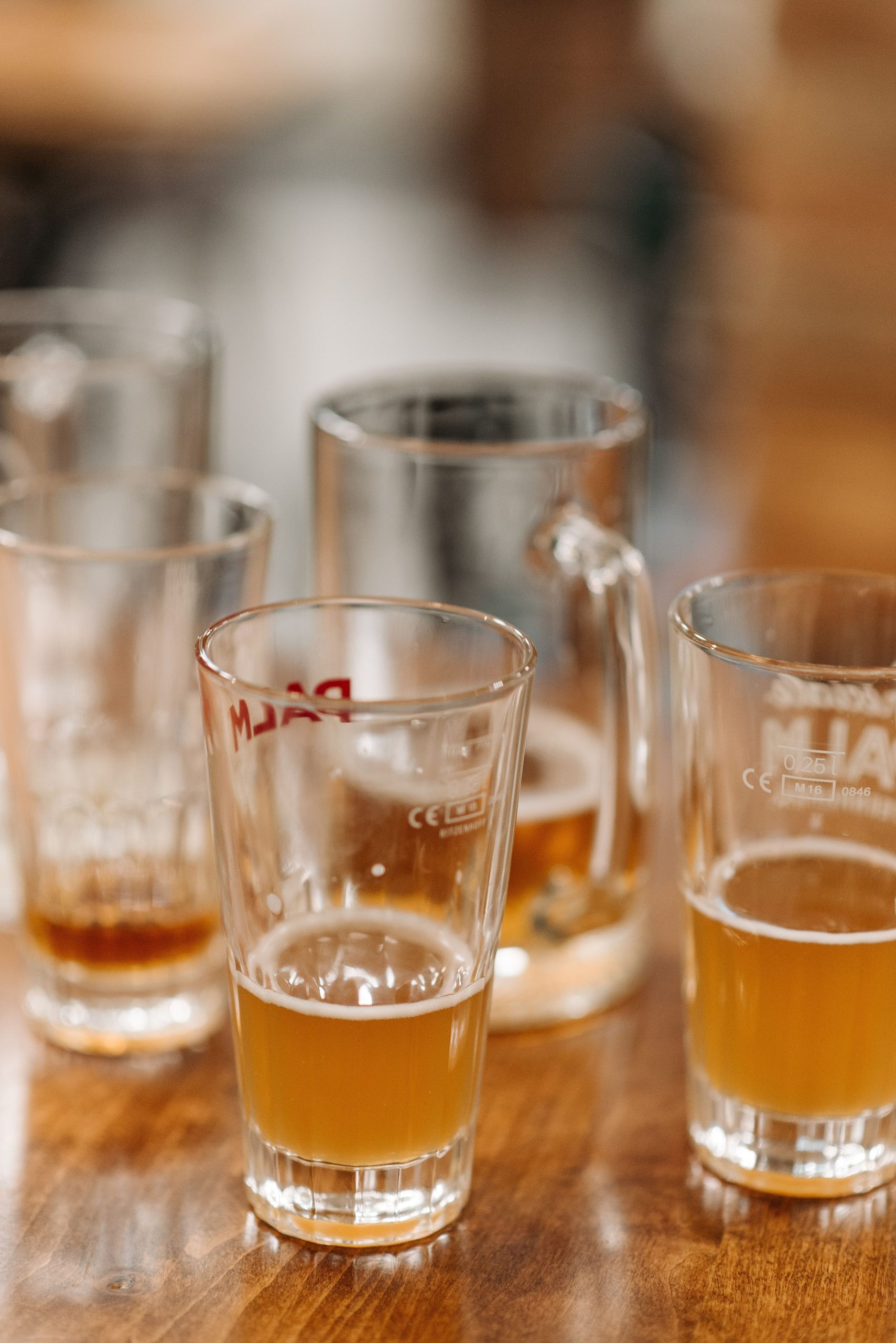Foto de vários pints de cerveja quase vazios sobre uma mesa