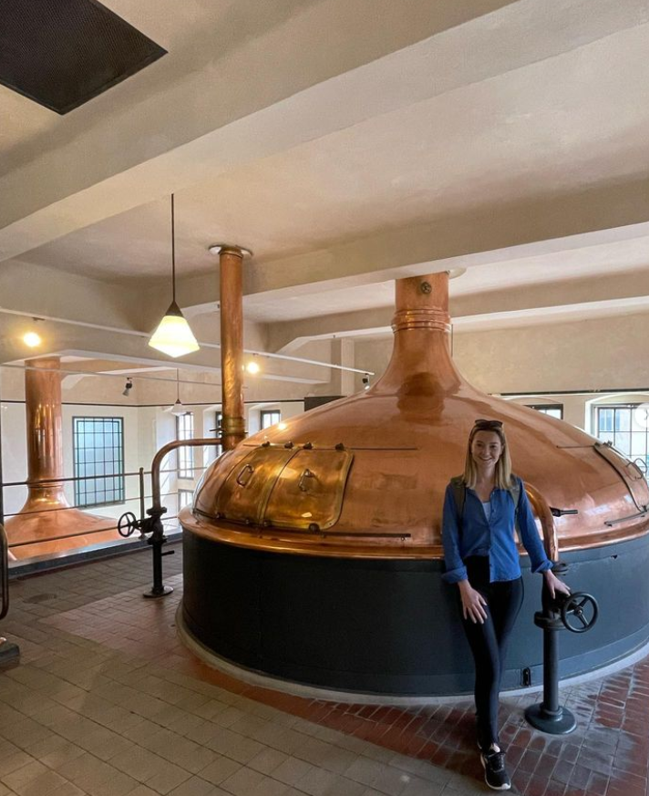 foto de jana em frente à um tanque produzindo cerveja