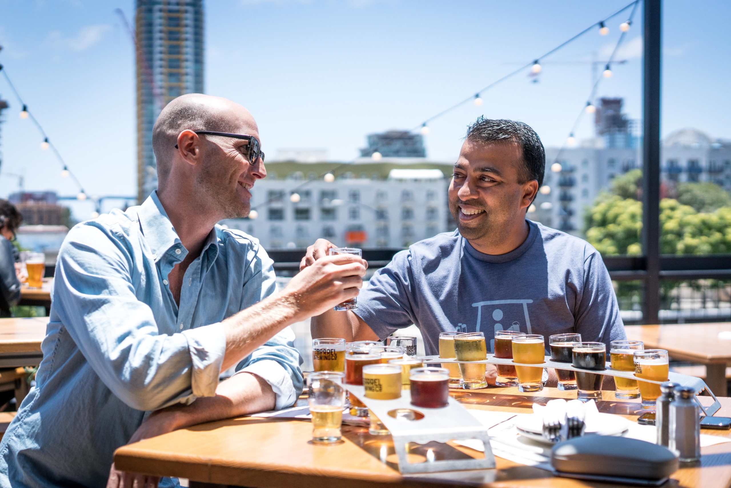 Duas pessoas com roupa social brindando e experimentando cervejas