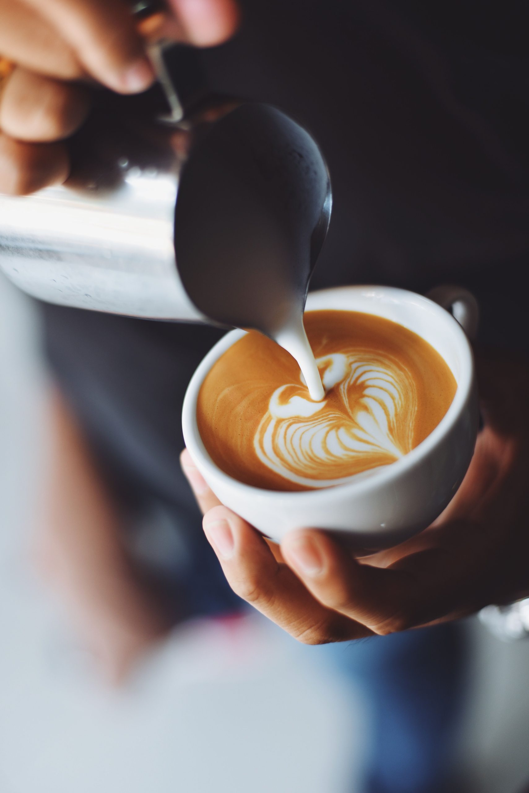 mão servindo café latte